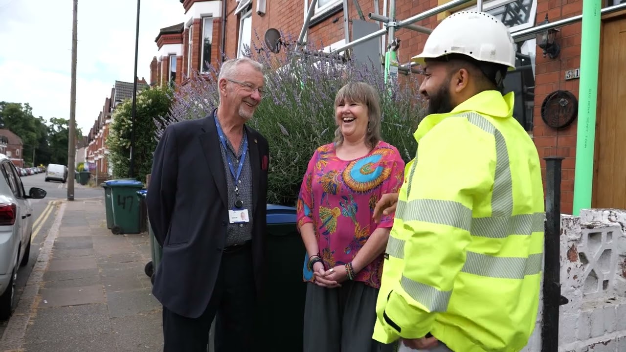 A site manager talking with residents outside their home during a retrofit programme